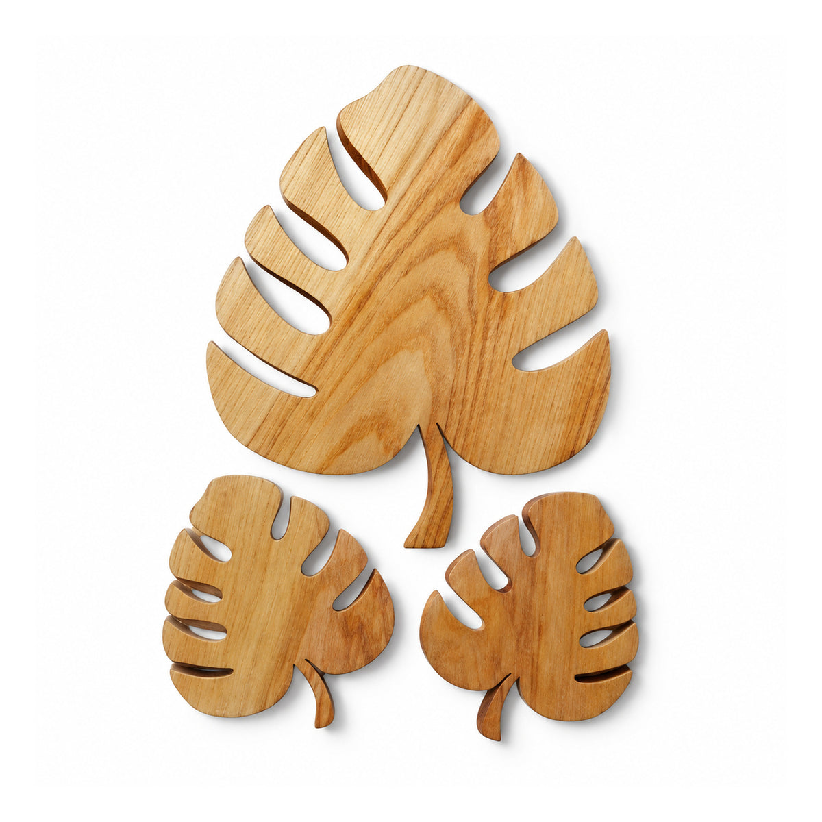 Three wooden monstera leaf wall decorations, one large and two smaller, with split leaves and natural golden-brown grain